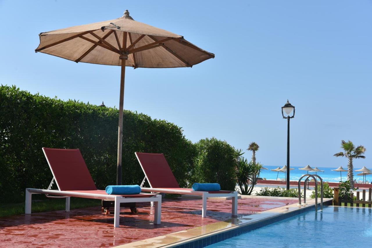 Tolip North Coast Hotel El Alamein Bagian luar foto A poolside umbrella