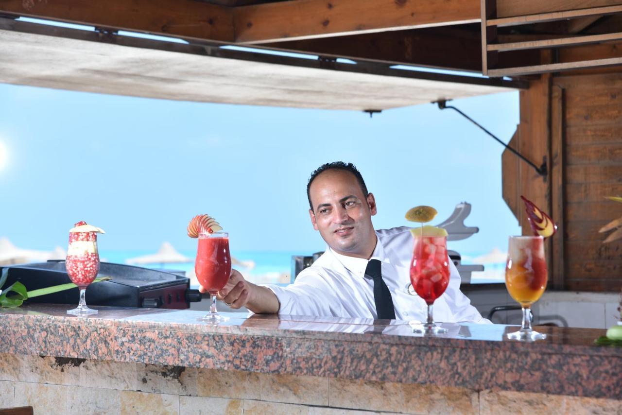 Tolip North Coast Hotel El Alamein Bagian luar foto A bartender at work